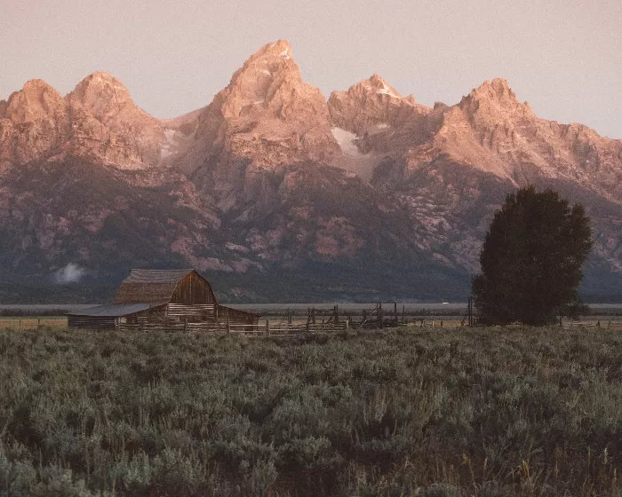 Barn at the foot of craggy mountains