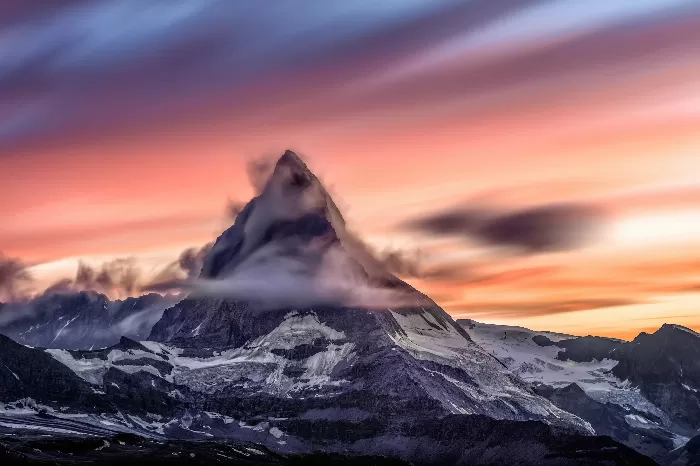 Snowcapped mountain peak on a cloudy sunrise in Matterhorn