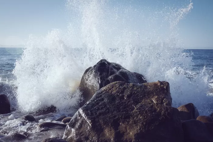 A wave splashing into a coastal rock